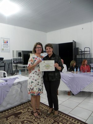 A Secretária Municipal de Assistência Social, Senhora Marcia Regina Fattore entregando o certificado à senhora Olga Zuchetto